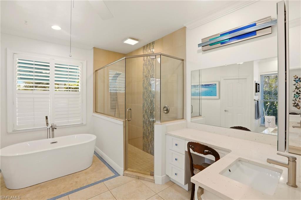 11180 Phoenix Way Naples, FL 34119 - Photo 17 of 43 Bathroom featuring a stall shower, vanity, light tile patterned flooring, and a freestanding bath