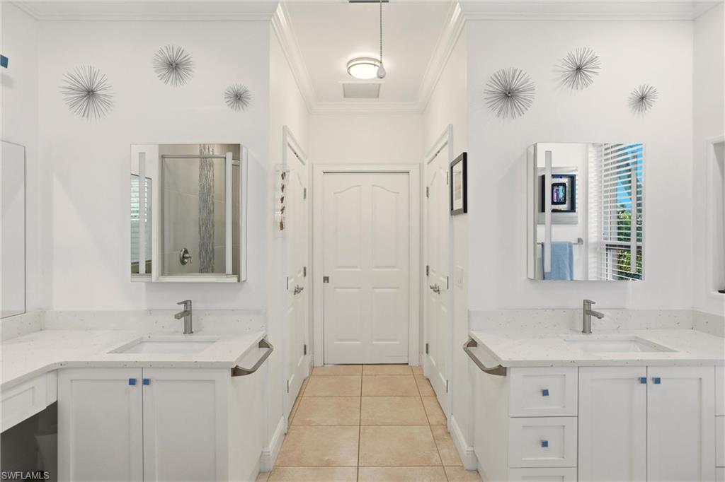 11180 Phoenix Way Naples, FL 34119 - Photo 19 of 43 Bathroom with two vanities, a shower stall, crown molding, and light tile patterned flooring