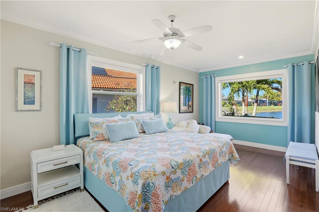 11180 Phoenix Way Naples, FL 34119 - Photo 20 of 43 Bedroom featuring hardwood / wood-style floors, multiple windows, ceiling fan, a water view, and ornamental molding