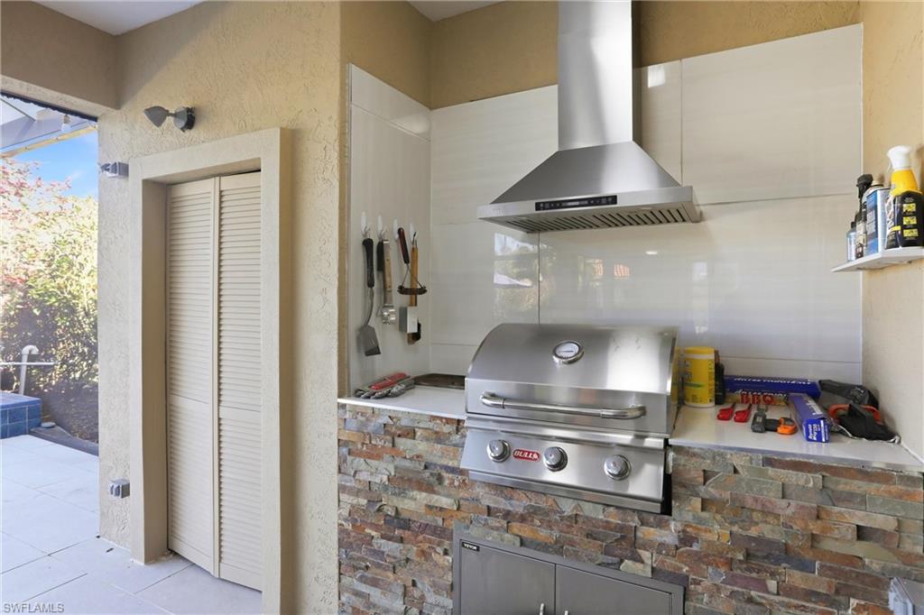11180 Phoenix Way Naples, FL 34119 - Photo 29 of 43 Kitchen with wall chimney range hood and a textured wall