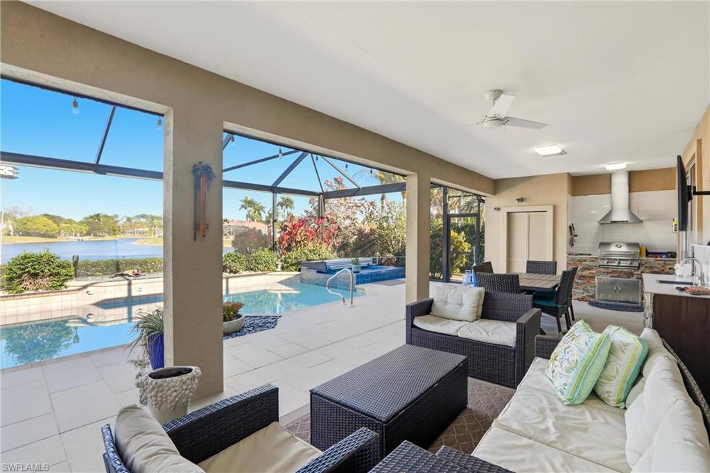 11180 Phoenix Way Naples, FL 34119 - Photo 31 of 43 Living room with a sunroom, a water view, tile patterned flooring, and a ceiling fan