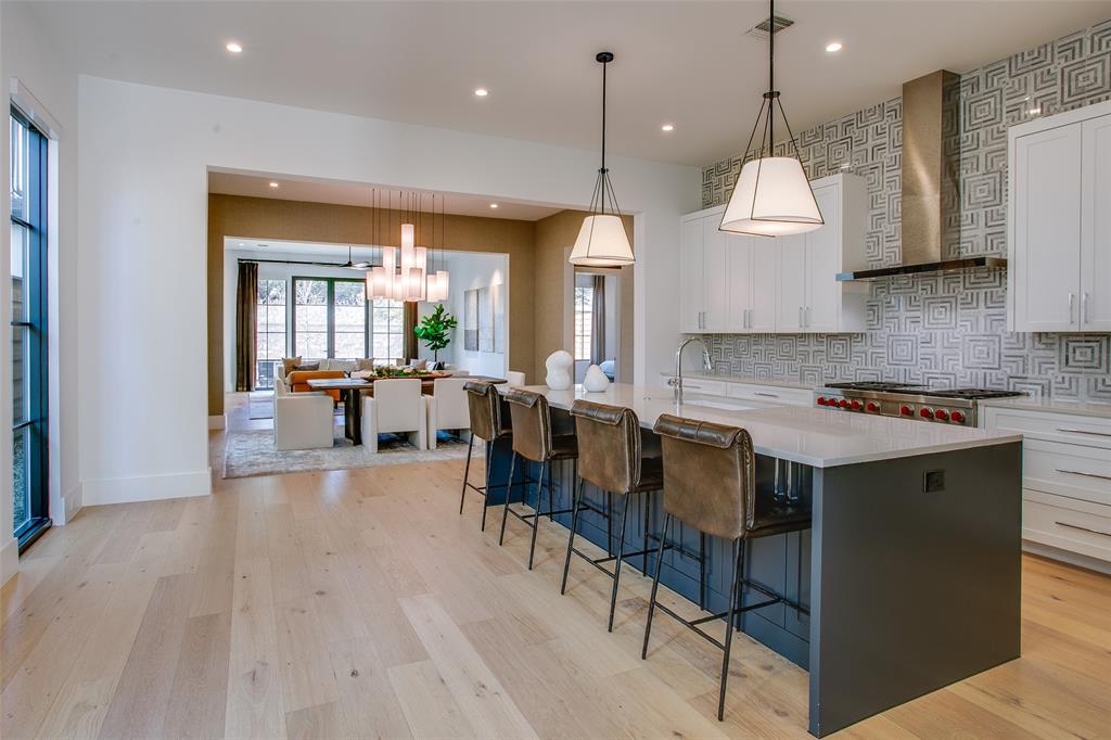 9721 Kerrisdale Lane Dallas, TX 75230 - Photo 25 of 25 a open kitchen with granite countertop a stove a sink a dining table and chairs with wooden floor