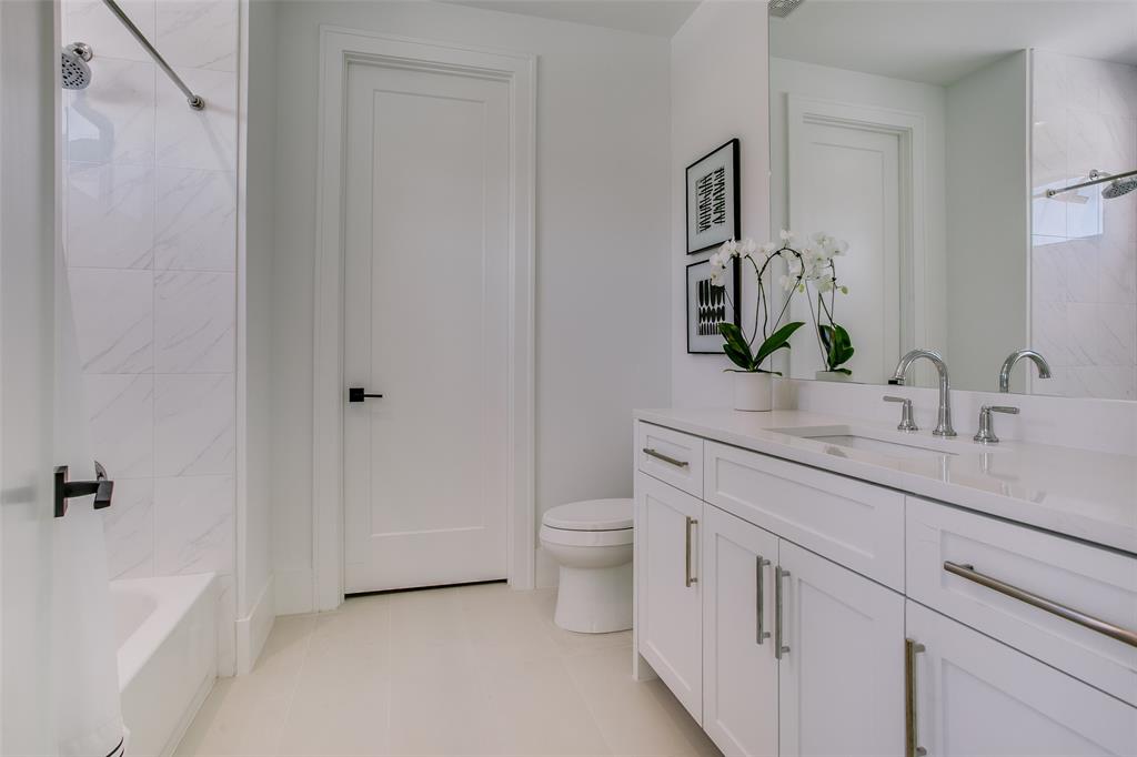 9721 Kerrisdale Lane Dallas, TX 75230 - Photo 17 of 25 a bathroom with a granite countertop sink a toilet and a shower