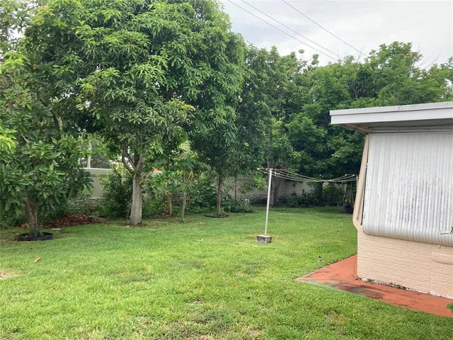 a backyard of a house with table and chairs plants