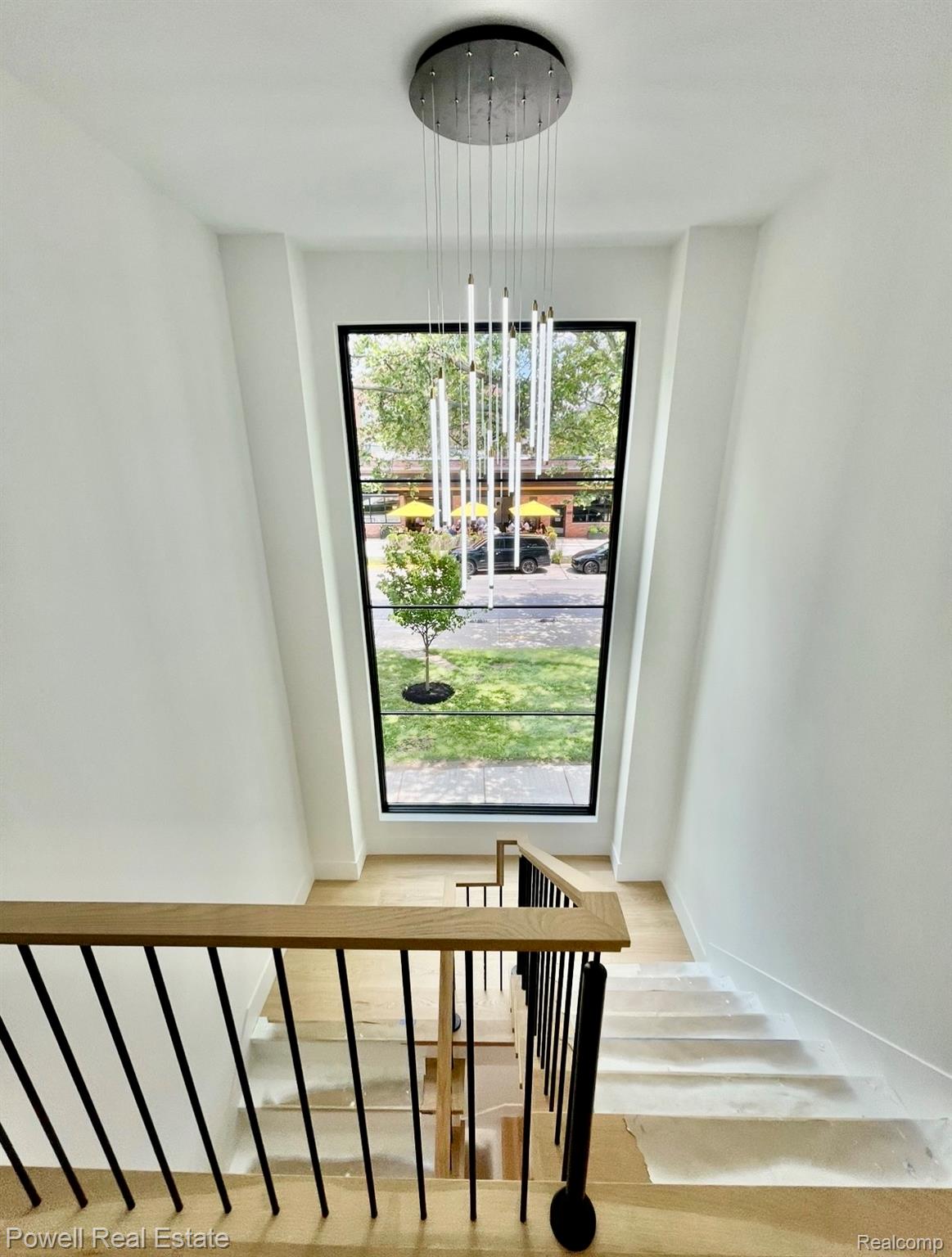 1998 Hazel Street Birmingham, MI 48009 - Photo 12 of 22 Modern multi-level staircase featuring light wood-finish treads and railings with black metal balusters