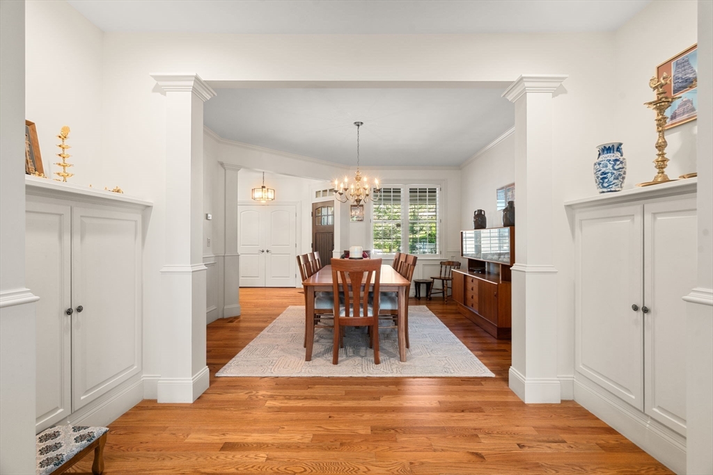 287 Langley Road, Unit 43 Newton, MA 02459 - Photo 6 of 36 a dining room with wooden floor a chandelier a wooden table and chairs