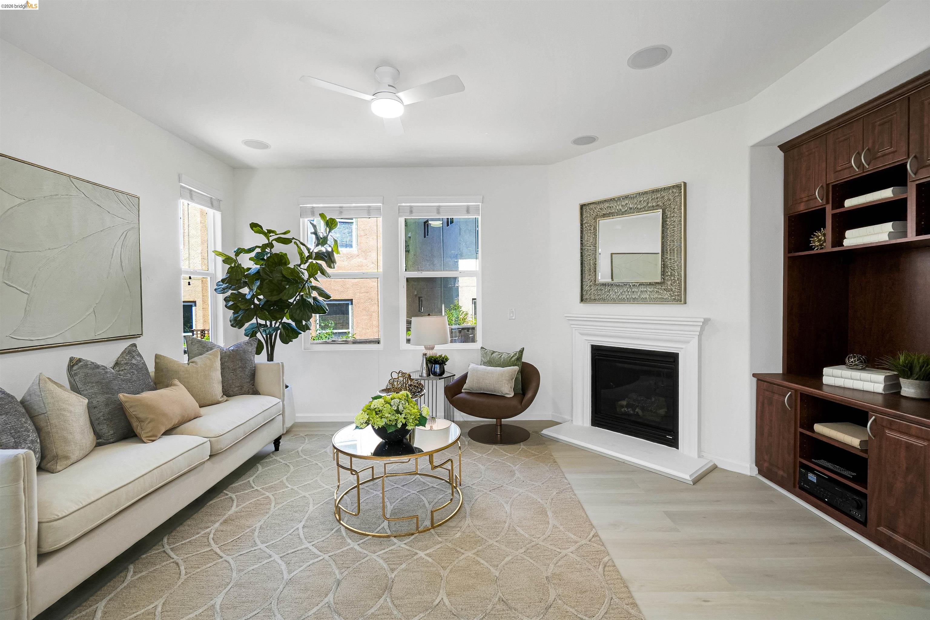 449 Constantine Court San Ramon, CA 94583 - Photo 15 of 63 Spacious living area featuring light wood-finish flooring, multiple windows, a white ceiling fan, and a fireplace with a white mantel