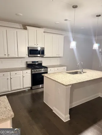 a kitchen with stainless steel appliances granite countertop a sink a stove a microwave and cabinets