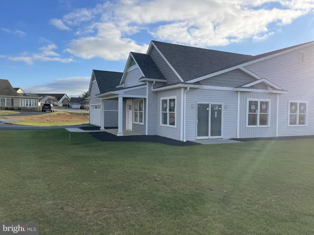 a view of a big house with a big yard and large trees