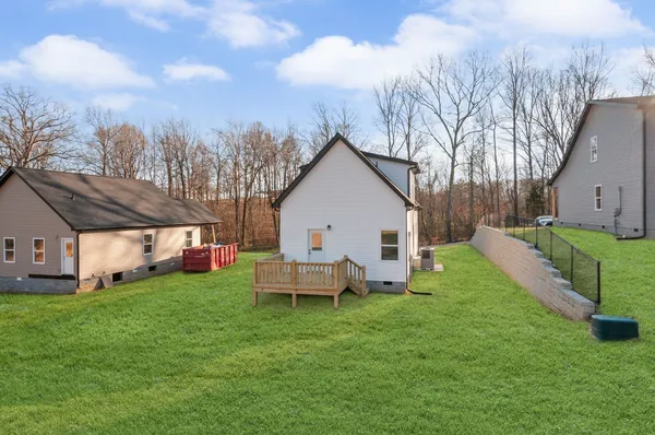 a view of a house with backyard and a tree