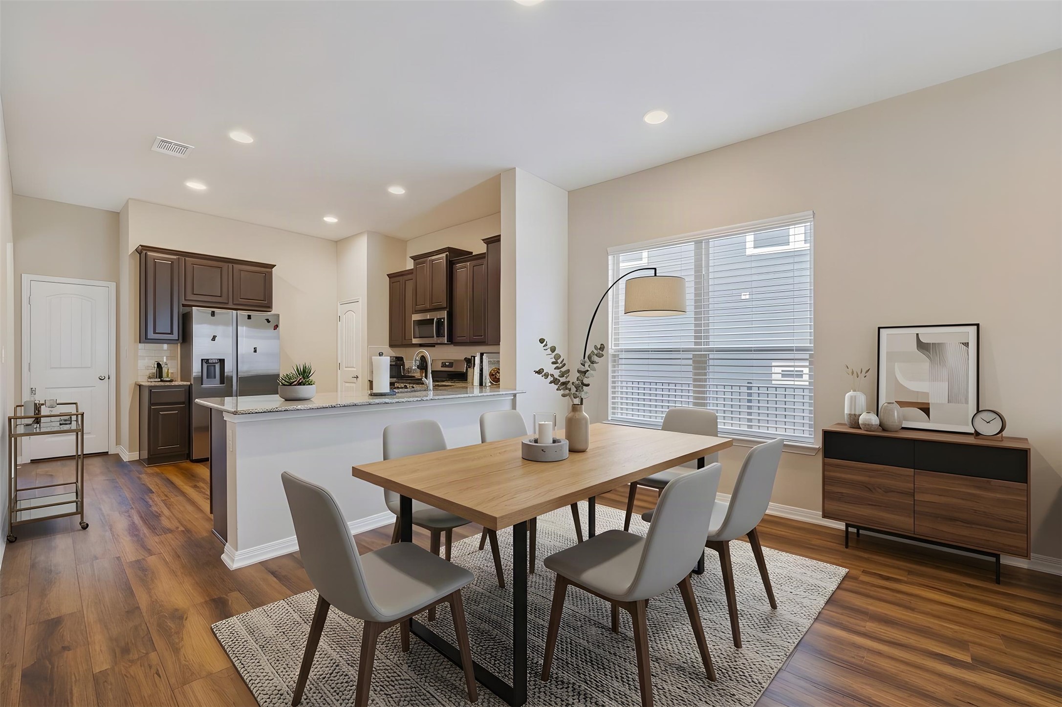 162 Rains Kyle, TX 78640 - Photo 11 of 32 Virtually staged - Dining area flows into the kitchen with recessed lighting and warm wood-like flooring.