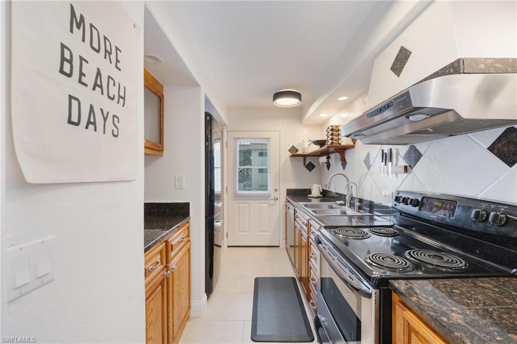 72 7th Street South, Unit 206 Naples, FL 34102 - Photo 11 of 38 a kitchen with a stove and a white refrigerator