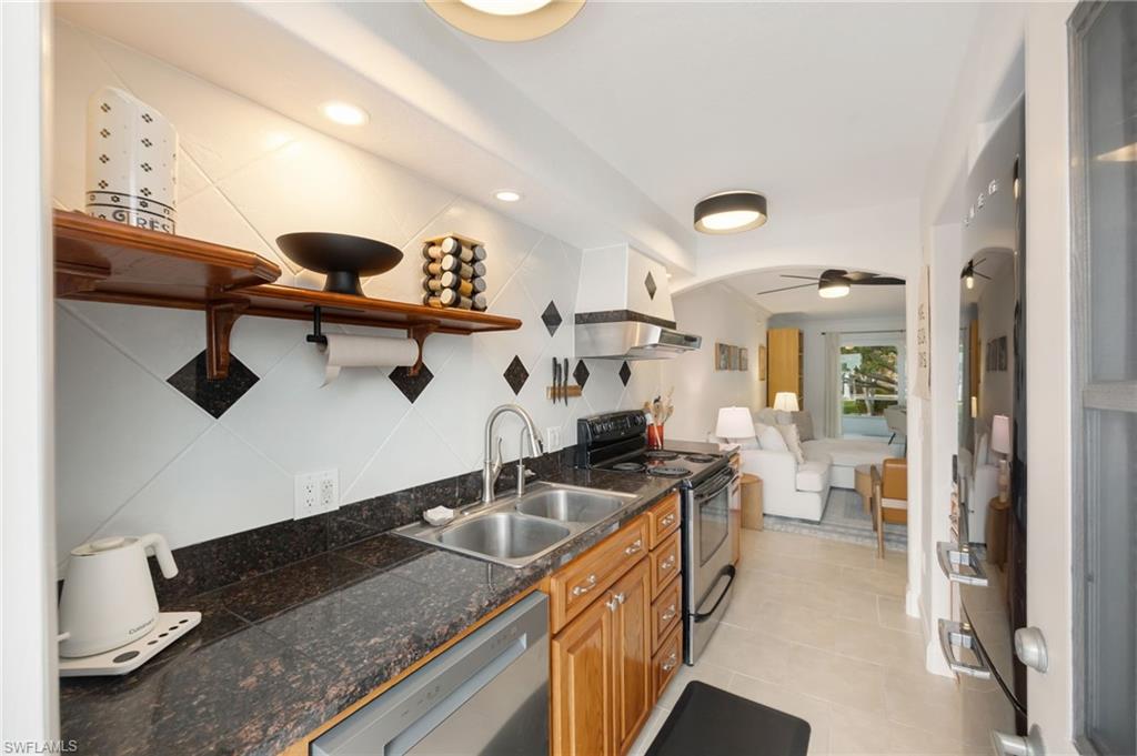 72 7th Street South, Unit 206 Naples, FL 34102 - Photo 12 of 38 a kitchen with a sink and a refrigerator