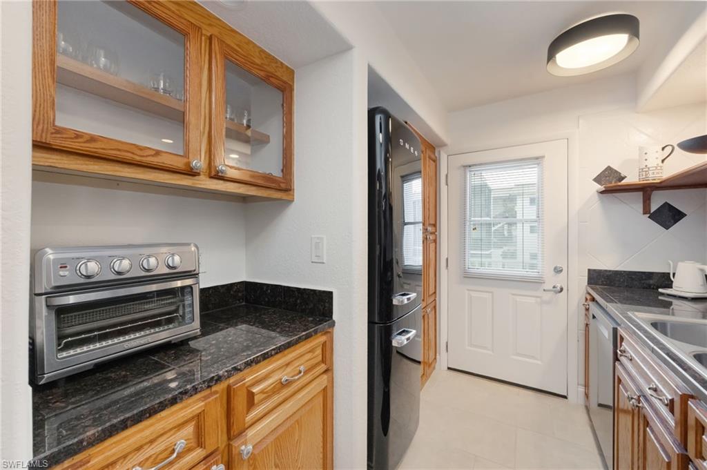72 7th Street South, Unit 206 Naples, FL 34102 - Photo 13 of 38 a kitchen with stainless steel appliances granite countertop a stove and a refrigerator