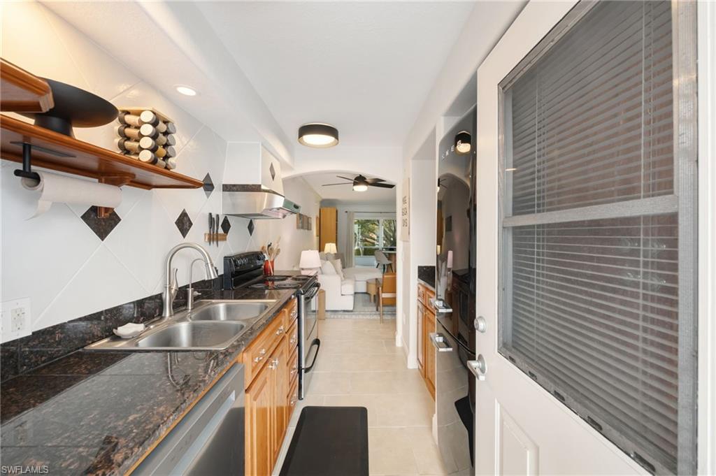 72 7th Street South, Unit 206 Naples, FL 34102 - Photo 14 of 38 a kitchen with granite countertop a sink and a stove