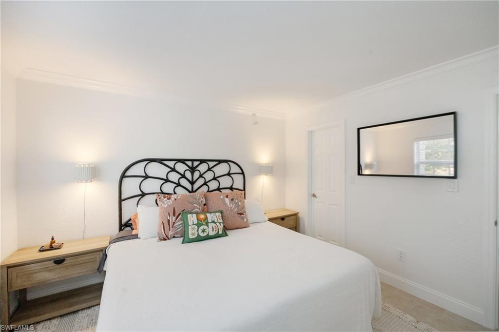 72 7th Street South, Unit 206 Naples, FL 34102 - Photo 16 of 38 a bedroom with a bed and a painting on the wall