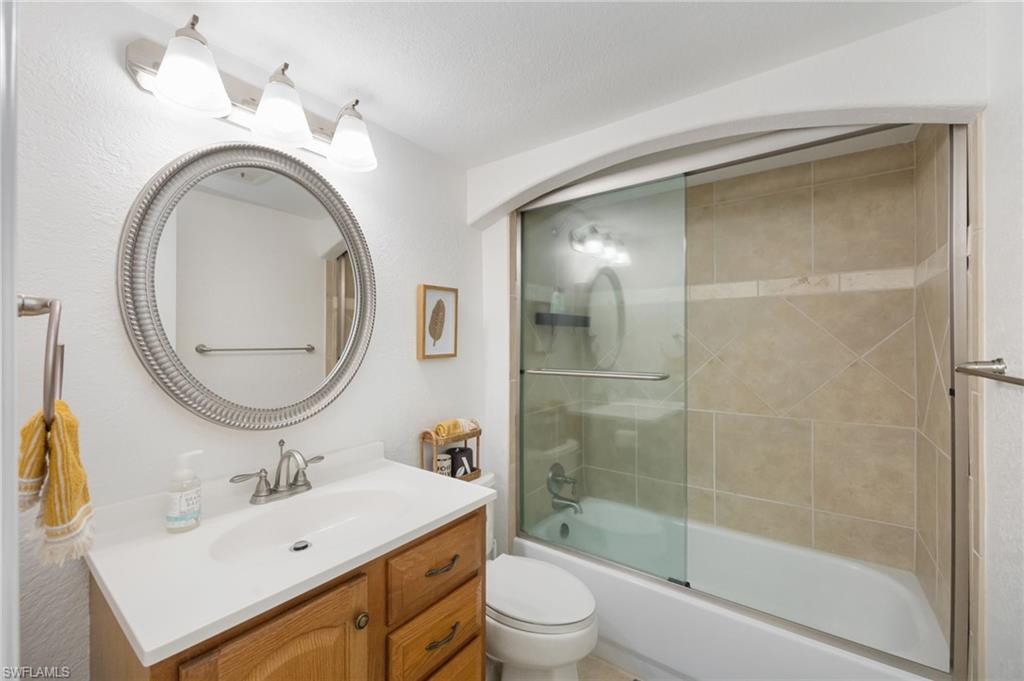 72 7th Street South, Unit 206 Naples, FL 34102 - Photo 18 of 38 a bathroom with a sink a toilet and a mirror