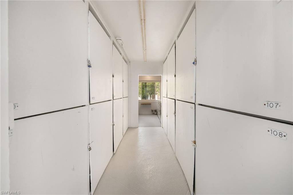 72 7th Street South, Unit 206 Naples, FL 34102 - Photo 22 of 38 a view of a hallway with a white refrigerator stove and washer