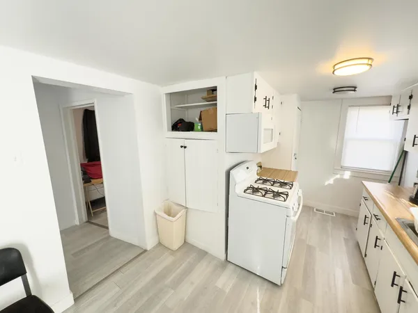a kitchen with a stove a refrigerator and a wooden floor