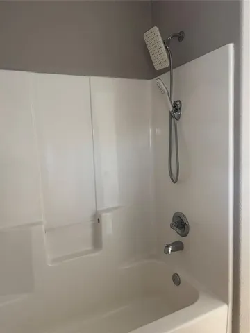 a bathroom with a bath tub with a shower