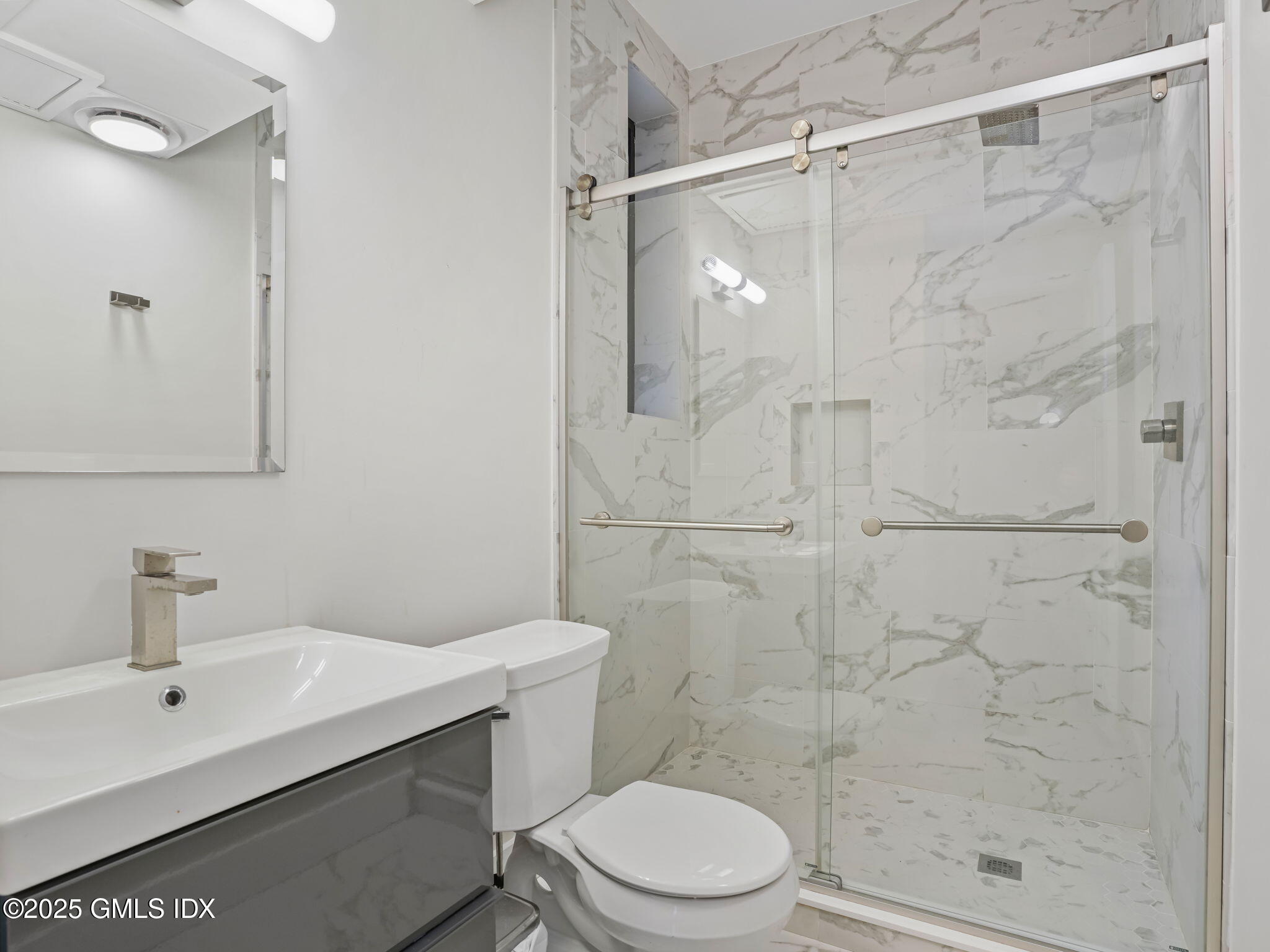 169 Greenwich Avenue, Unit FRONT Greenwich, CT 06830 - Photo 13 of 22 a bathroom with a shower sink vanity and toilet