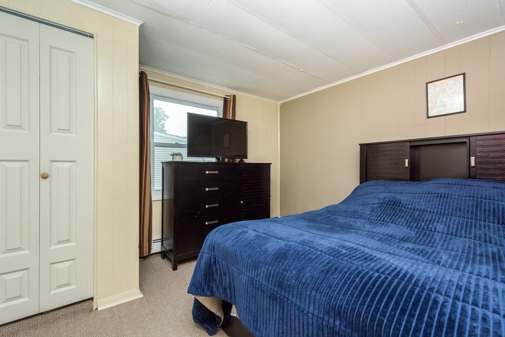 2 Lakeside Avenue Webster, MA 01570 - Photo 19 of 27 a bedroom with a bed and a flat tv screen on dresser