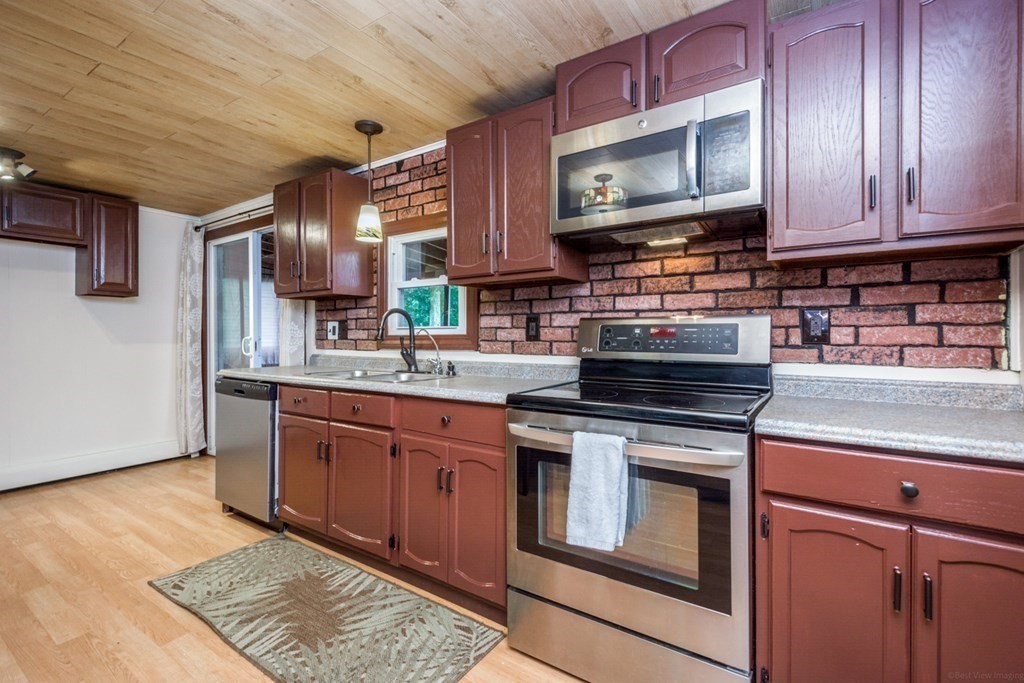 2 Lakeside Avenue Webster, MA 01570 - Photo 8 of 27 a kitchen with stainless steel appliances granite countertop a stove microwave and cabinets