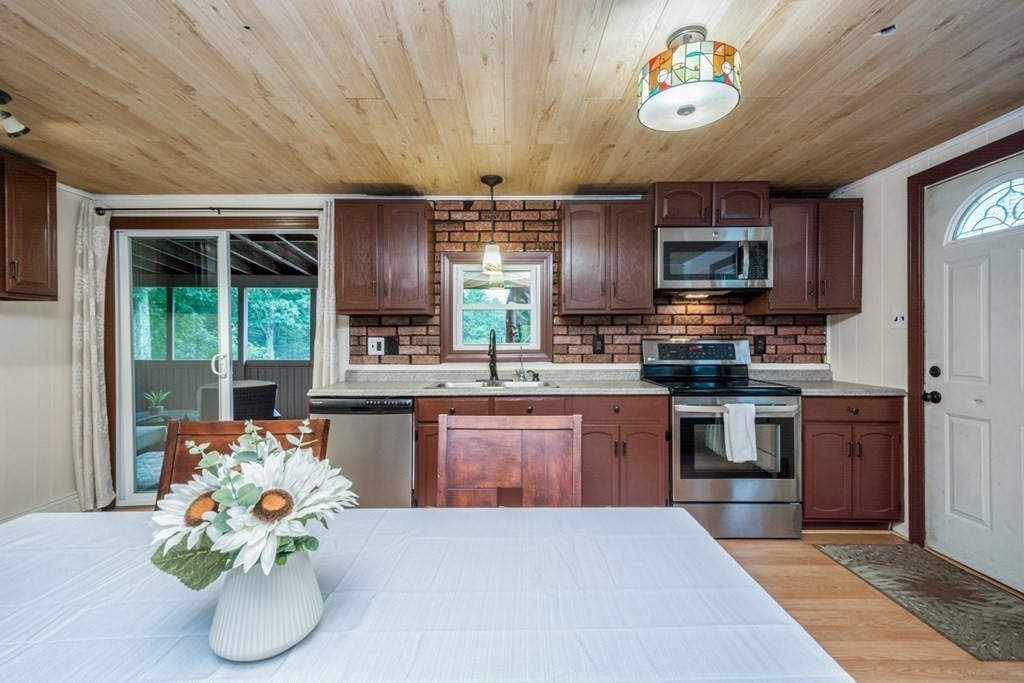 2 Lakeside Avenue Webster, MA 01570 - Photo 10 of 27 a kitchen with stainless steel appliances kitchen island granite countertop a stove refrigerator and microwave