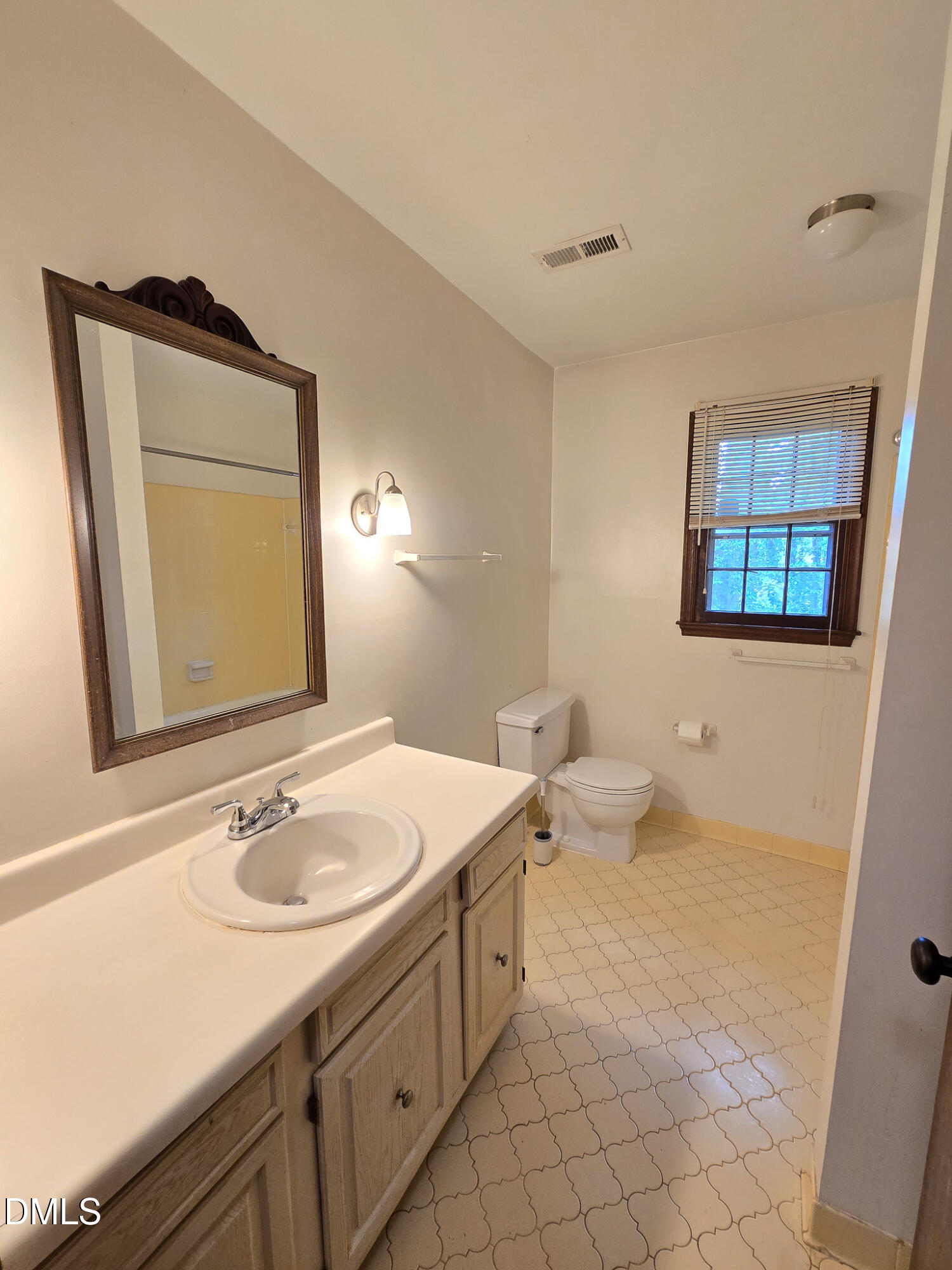 3909 Greenleaf Street Raleigh, NC 27606 - Photo 21 of 27 a bathroom with a toilet sink and mirror
