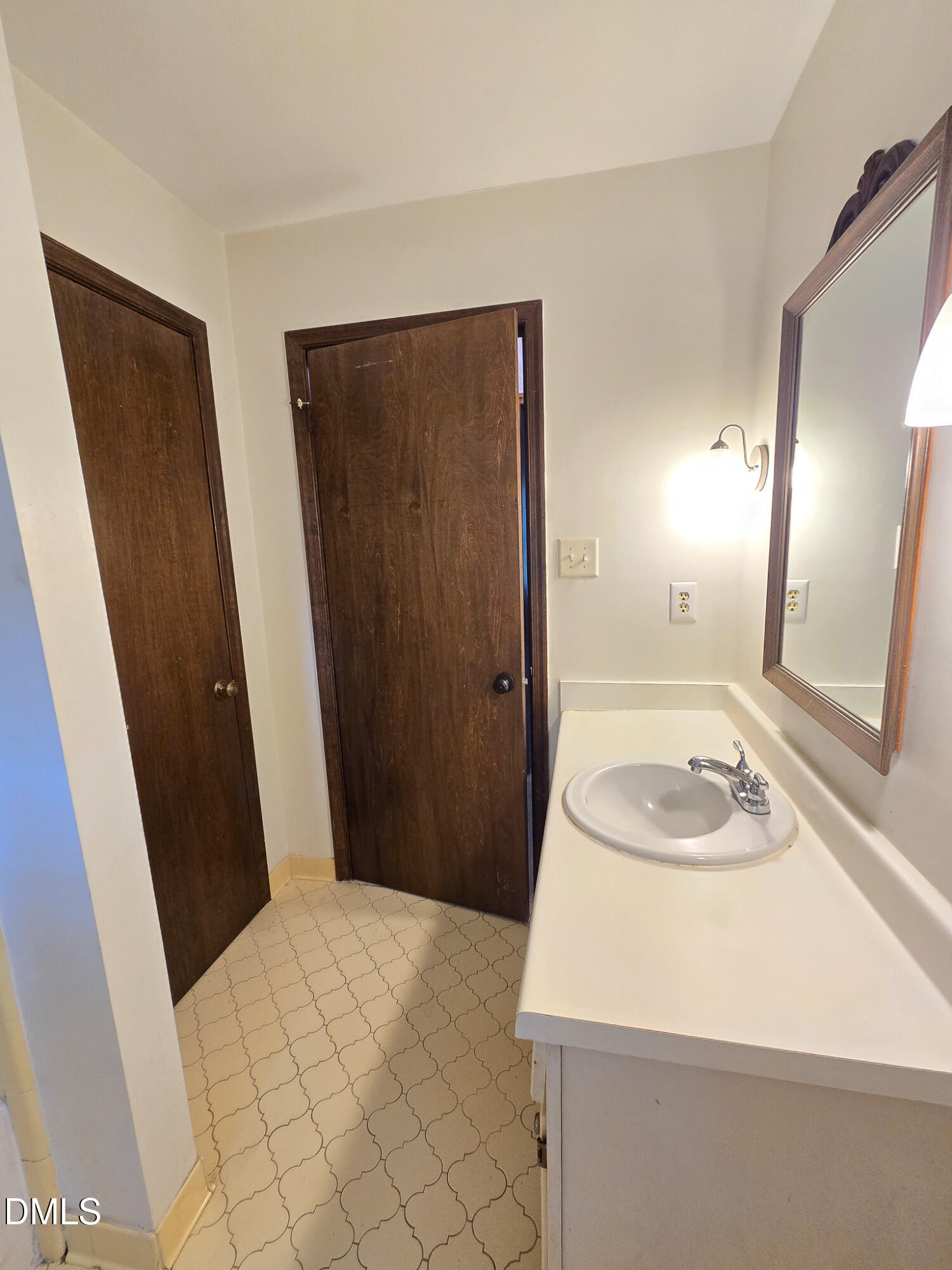 3909 Greenleaf Street Raleigh, NC 27606 - Photo 23 of 27 a bathroom with a sink a toilet a mirror and vanity