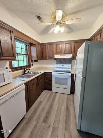 a kitchen with a sink stainless steel appliances a window and a counter top space