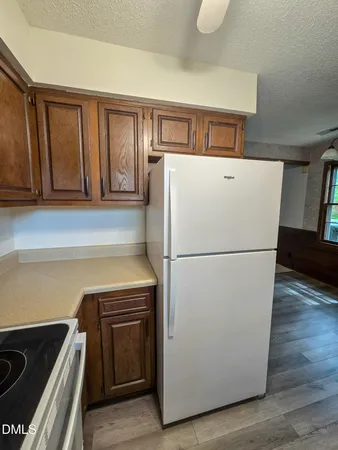 a white refrigerator freezer and a stove sitting inside of a kitchen