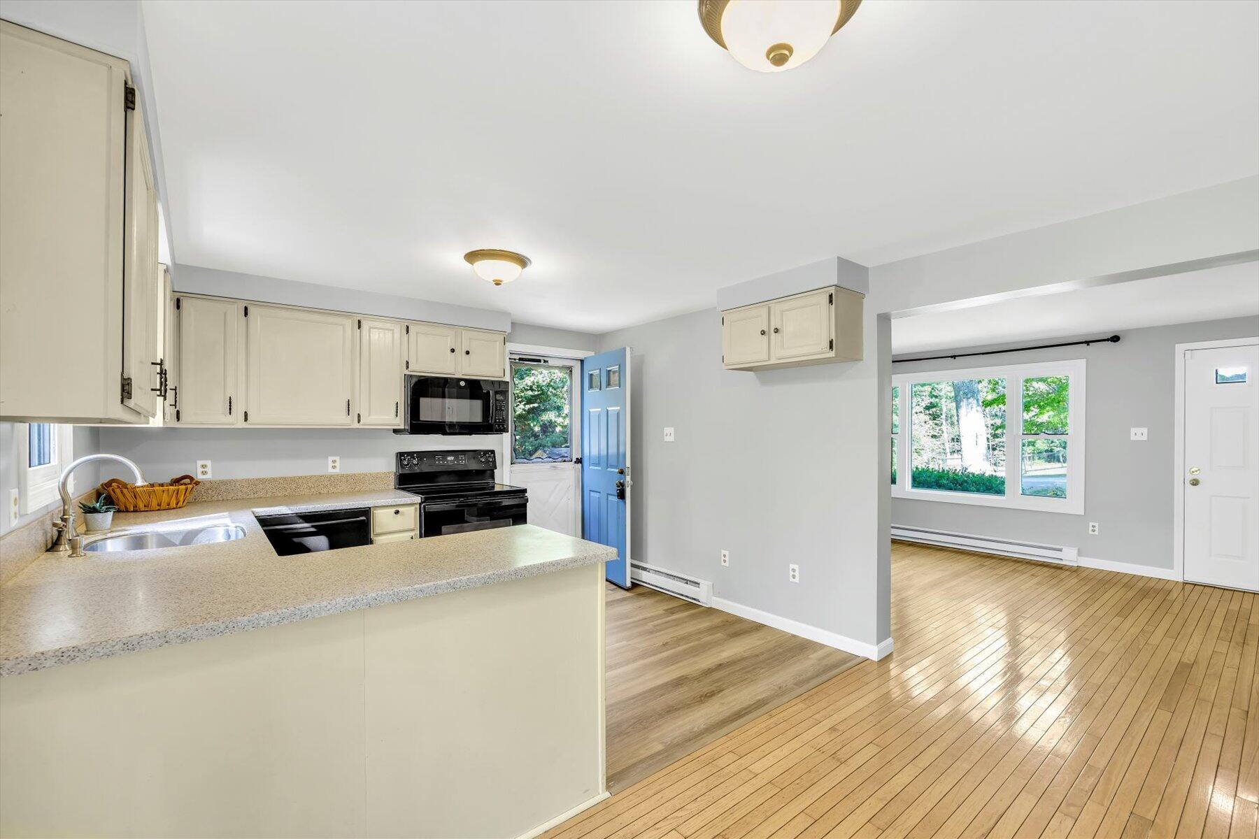59 Oregon Road Mashpee, MA 02649 - Photo 11 of 34 a kitchen with a sink a microwave and wooden floor