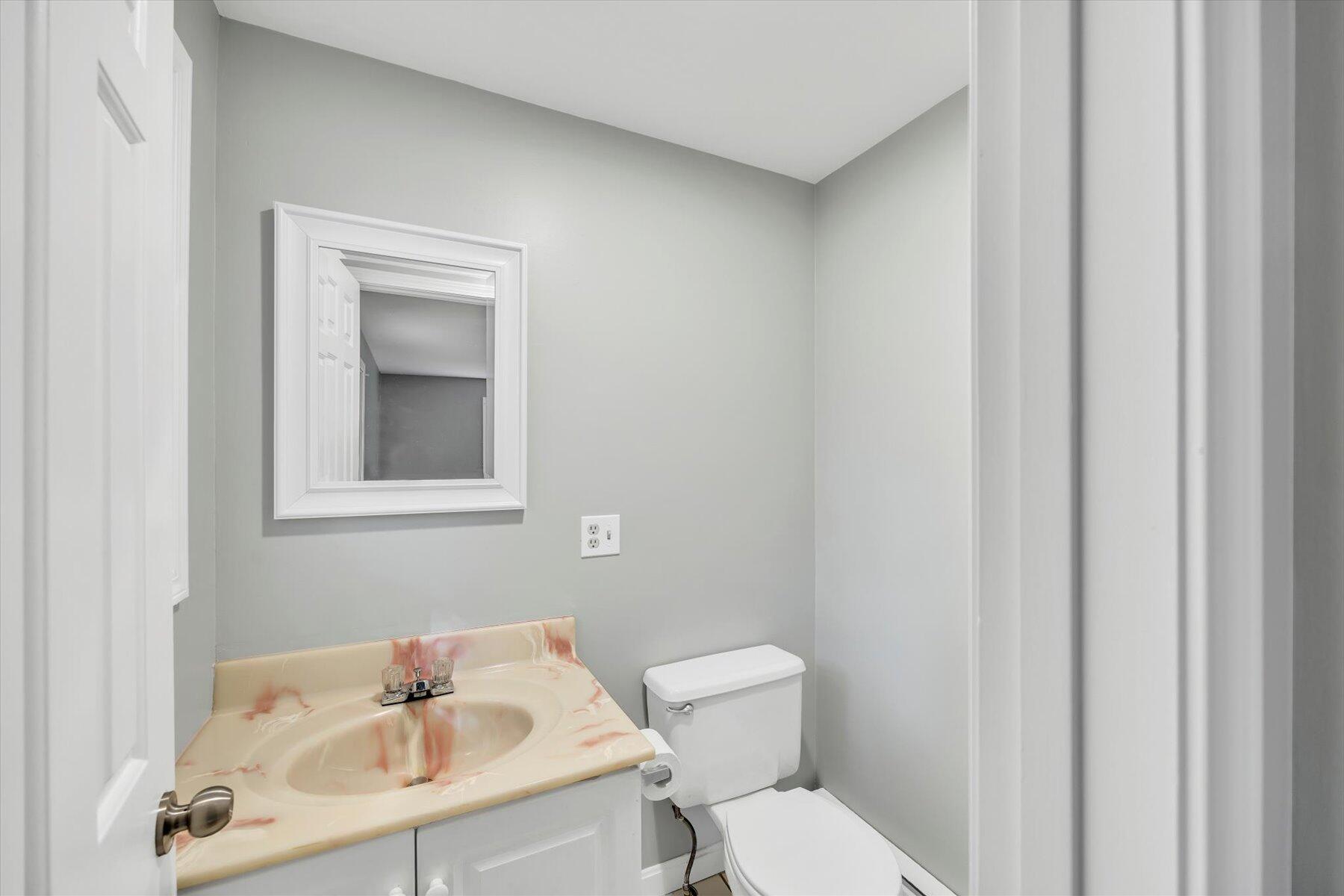 59 Oregon Road Mashpee, MA 02649 - Photo 23 of 34 a bathroom with a sink a toilet and a mirror