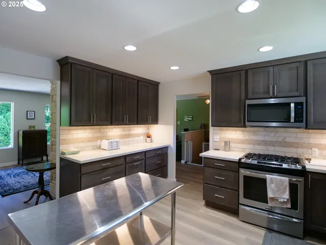 a kitchen with kitchen island granite countertop stainless steel appliances and wooden cabinets