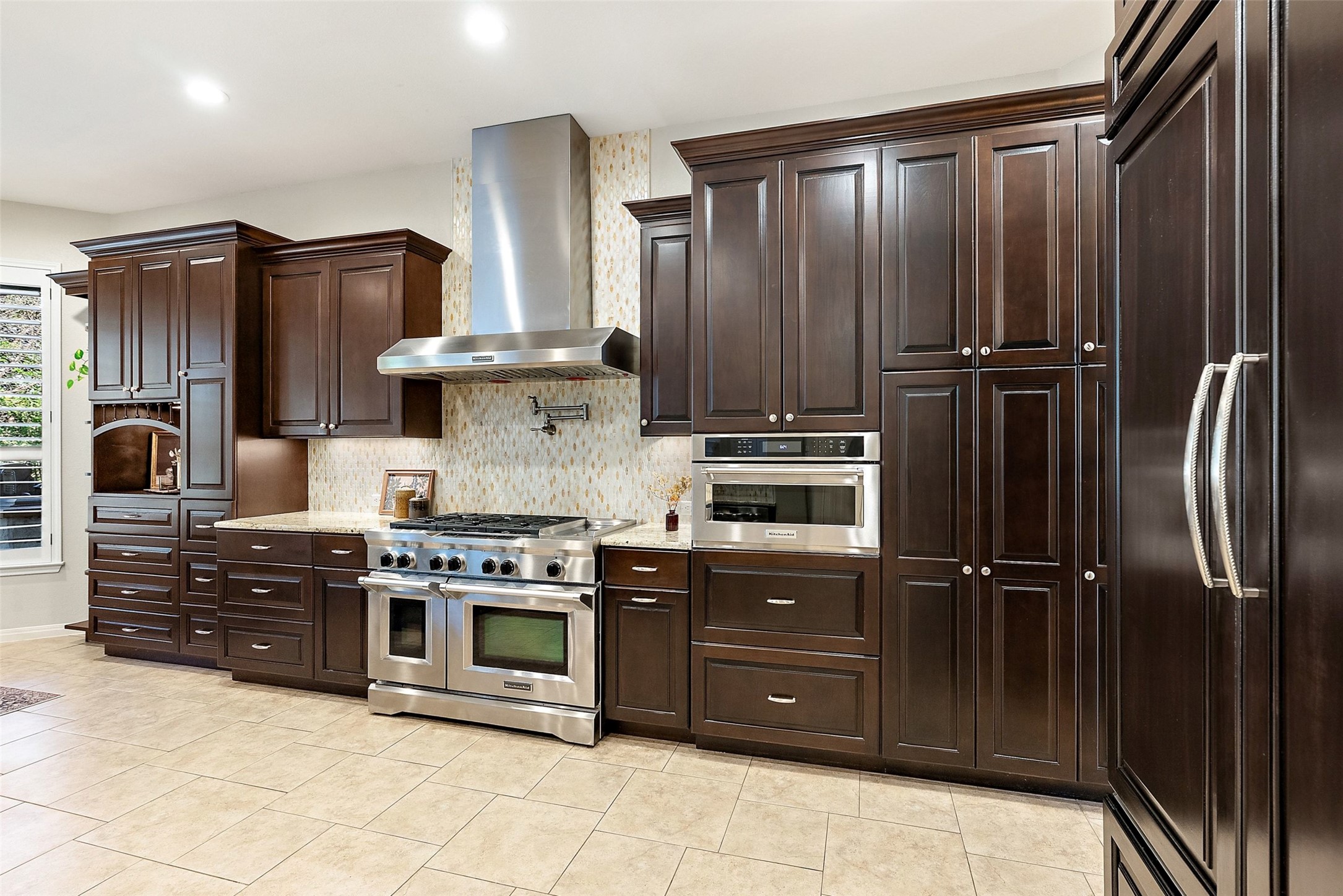 8215 Dark Ridge Cove Austin, TX 78737 - Photo 15 of 40 Culinary aspirations come alive in this kitchen, boasting premium appliances, upgraded cabinets, granite countertops, and ample space for entertaining.