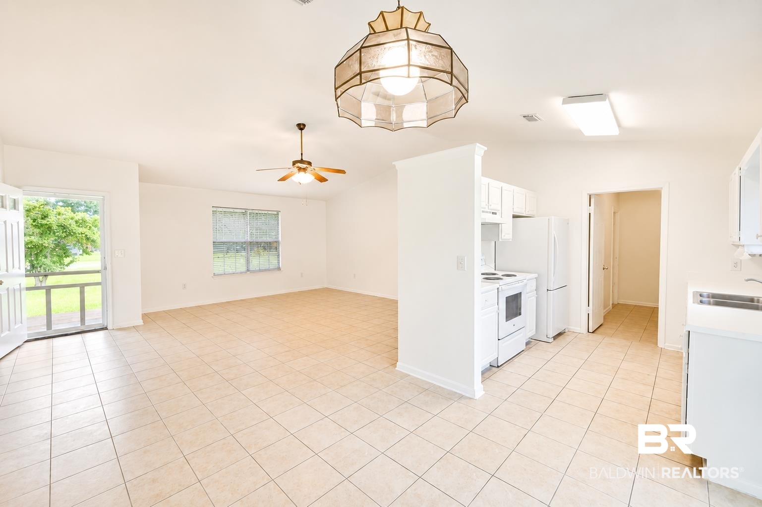 614 East Gate Circle Foley, AL 36535 - Photo 8 of 31 Open concept living space featuring neutral tile flooring, a ceiling fan, and a kitchen area with white cabinetry and appliances