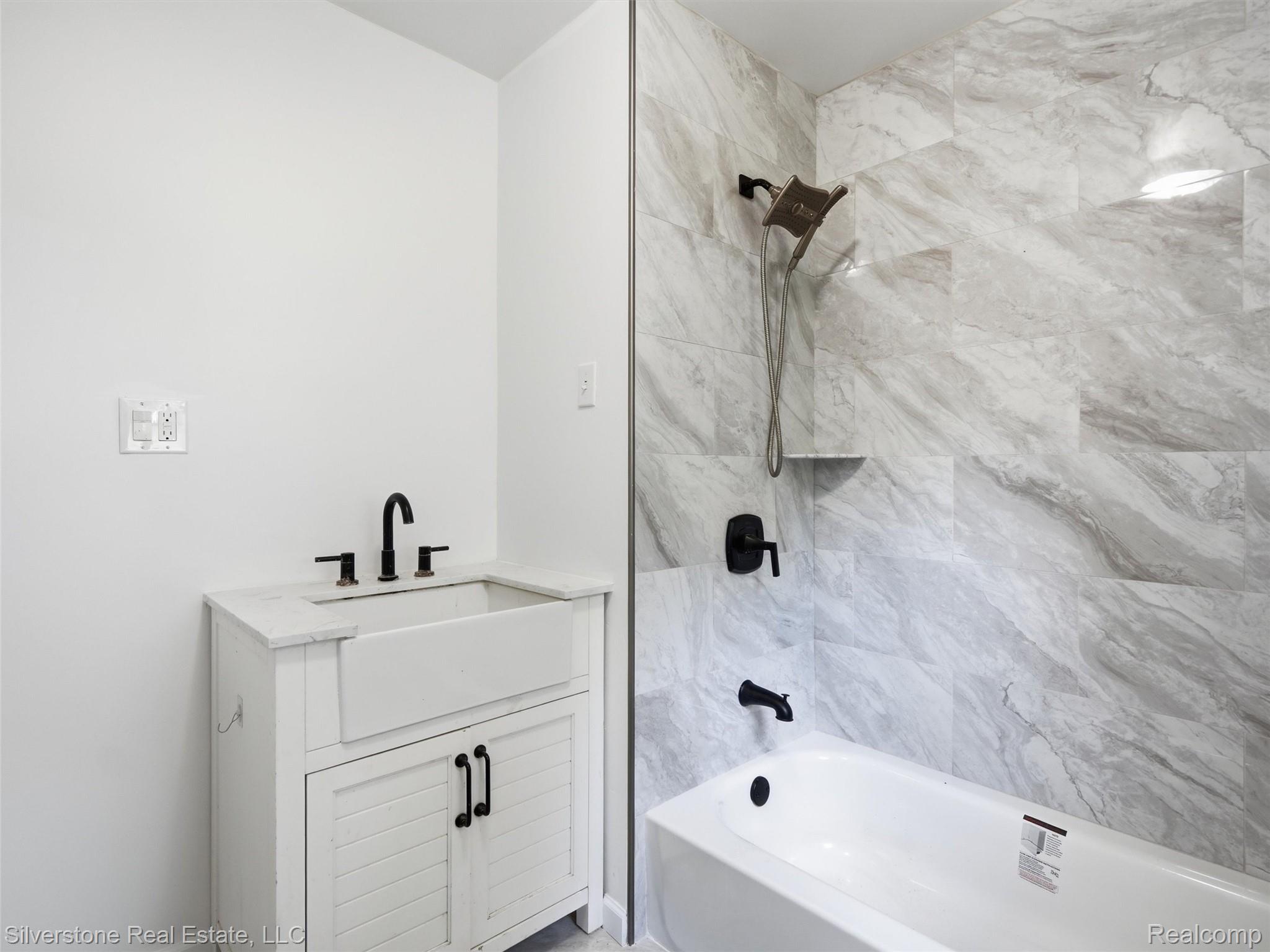 9691 Grames Road Maybee, MI 48159 - Photo 21 of 44 White farmhouse-style vanity with an integrated basin sink, black fixtures, and a white countertop