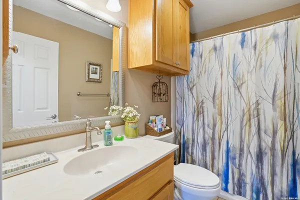 a bathroom with a sink a toilet and shower curtain