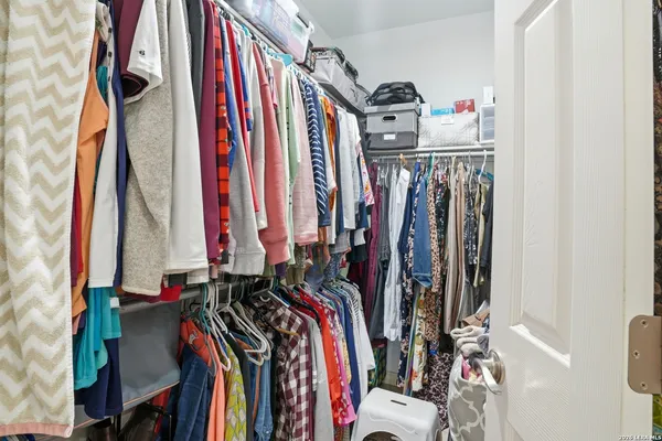 a view of walk in closet with clothes
