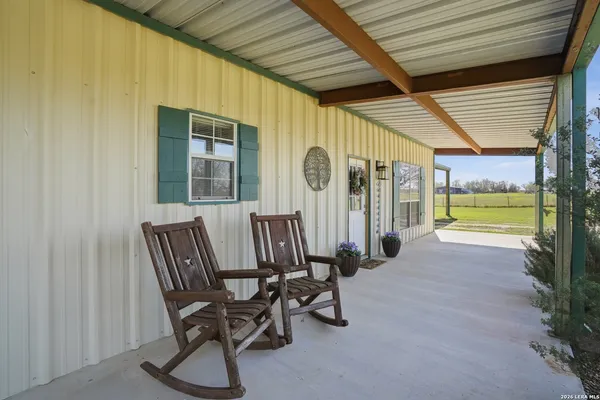a view of a porch with chairs and backyard