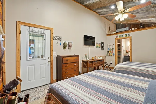 a bedroom with a bed and a flat tv screen on dresser