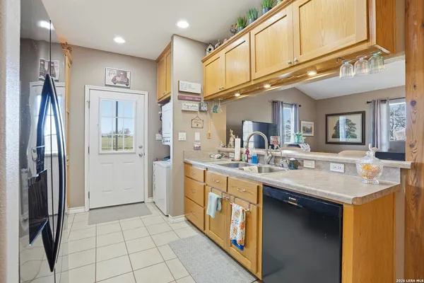a kitchen with stainless steel appliances granite countertop a sink a refrigerator and a stove