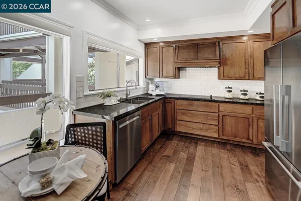 a kitchen with stainless steel appliances granite countertop a sink stove and cabinets