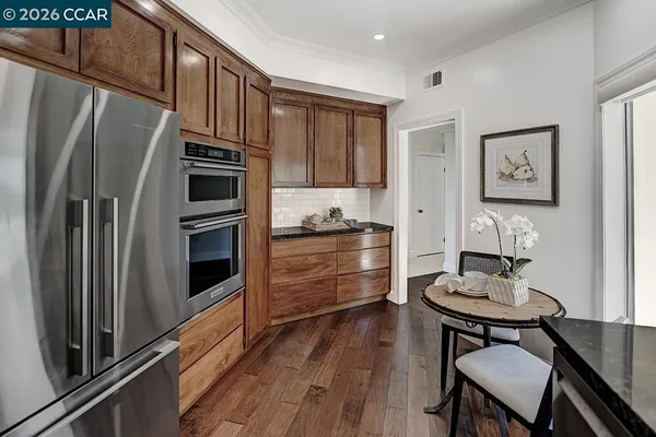 a kitchen with stainless steel appliances a refrigerator and a stove top oven