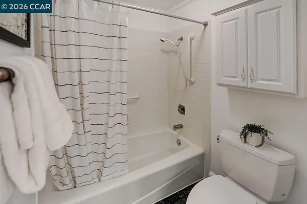 a bedroom with a bed and painting on the wall