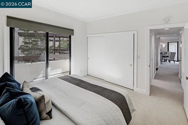 a view of a hallway with wooden floor closet and a living room
