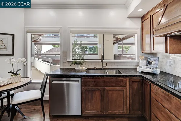 a kitchen with granite countertop a sink and wooden cabinets