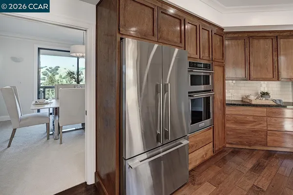 a kitchen with granite countertop a refrigerator and cabinets