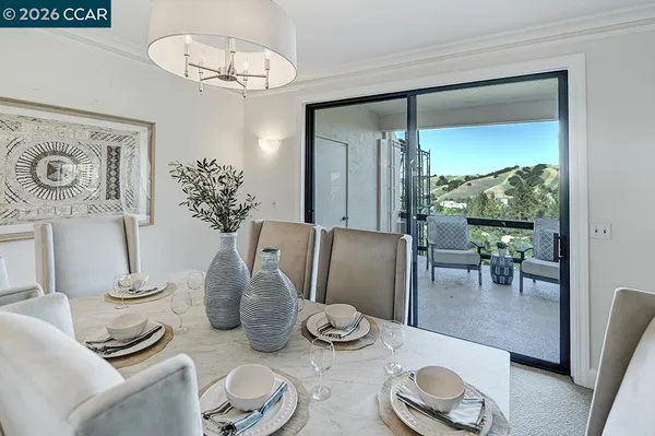 a dining room with furniture a chandelier and window